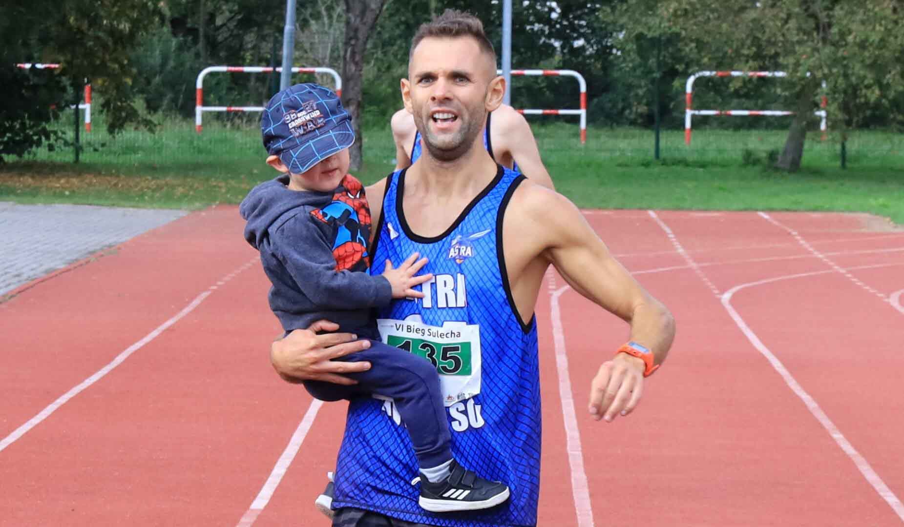 Mężczyzna biegnący z dzieckiem na ręku