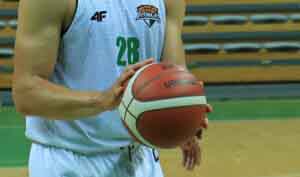 Ręce trzymające piłkę do koszykówki