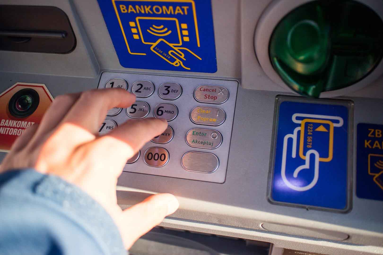 Dłoń na klawiaturze bankomatu