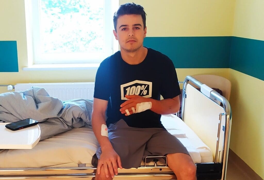 Młody mężczyzna siedzi na szpitalnym łóżku