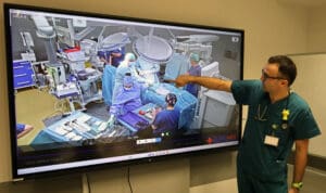 Lekarz przy ekranie, na którym widać zespół medyczny w trakcie zabiegu