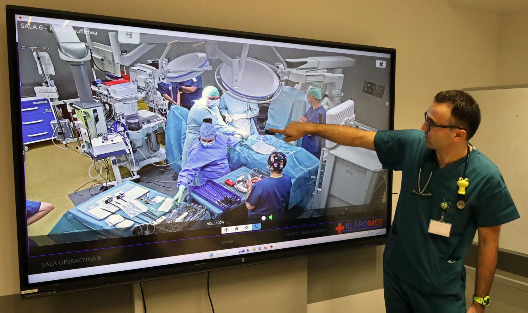Lekarz przy ekranie, na którym widać zespół medyczny w trakcie zabiegu