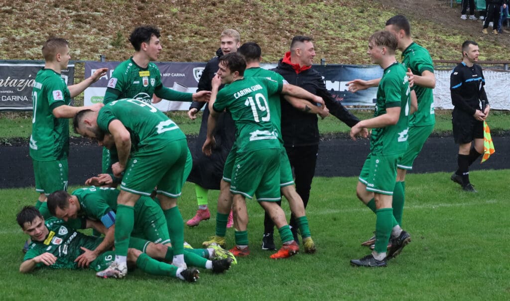 Grupa cieszących się mężczyzn na boisku