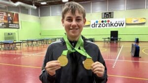 Uśmiechnięty chłopak z dwoma medalami