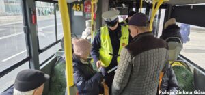 Policjant w autobusie MZK rozdaje odblaski