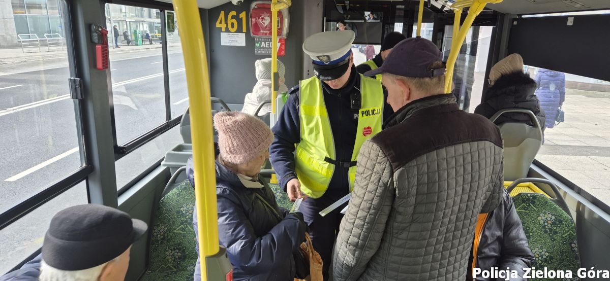 Policjant w autobusie MZK rozdaje odblaski