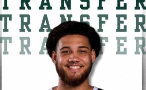 Twarz uśmiechniętego mężczyzny na tle napisu "transfer"