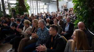 Kilkadziesiąt osób siedzących na krzesłach