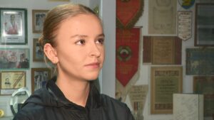 Kobieta na tle dyplomów i proporczyków