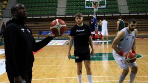 Trzech mężczyzn w sportowych strojach i z piłkami do koszykówki