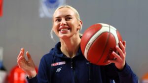 Uśmiechnięta kobieta z piłką do koszykówki