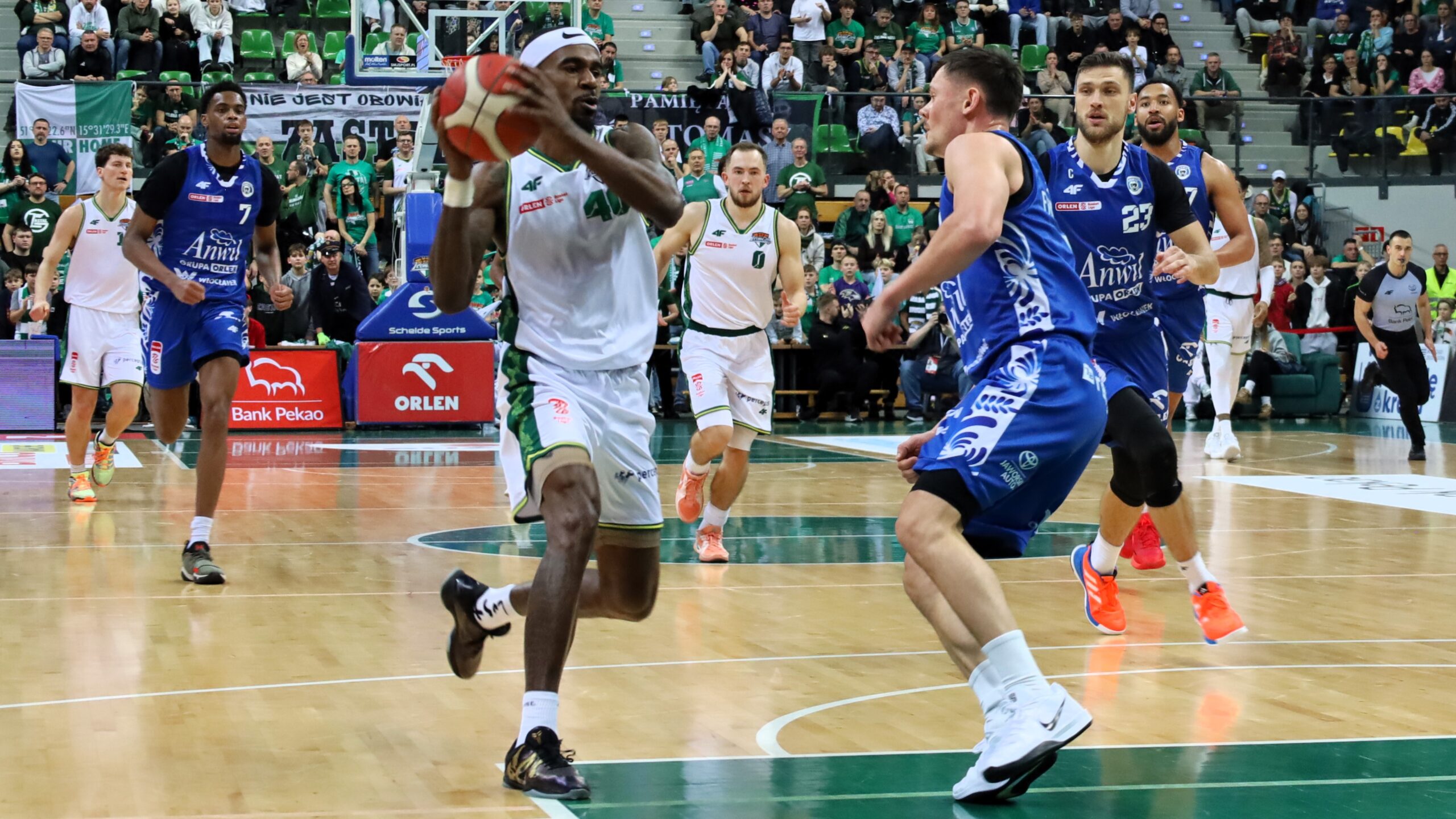 Ośmiu mężczyzn gra w koszykówkę